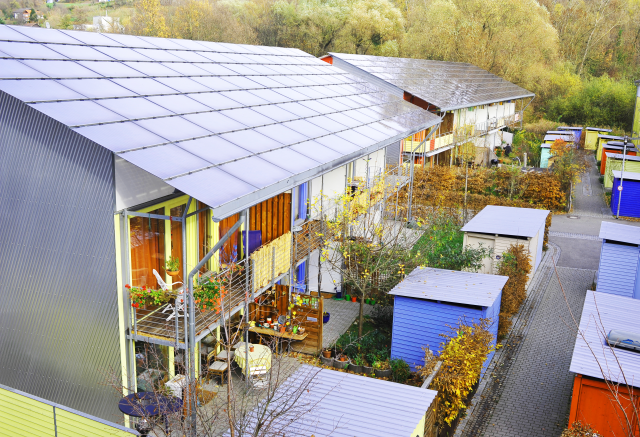 Zwei Häuser mit Solarpanels auf den Dächern, drumherum viele kleine Bungalows.
