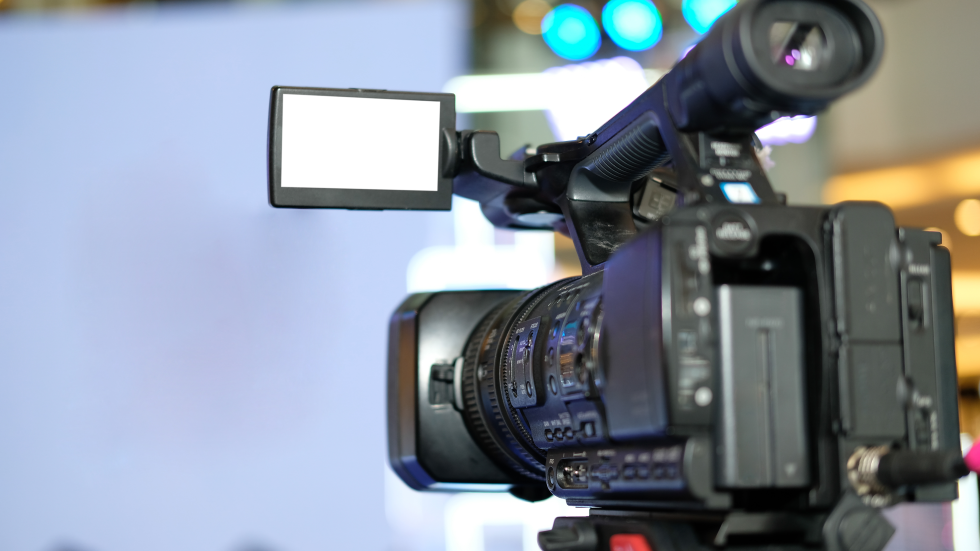 Eine professionelle Videokamera ist auf verschwommenen Hintergrund gerichtet.