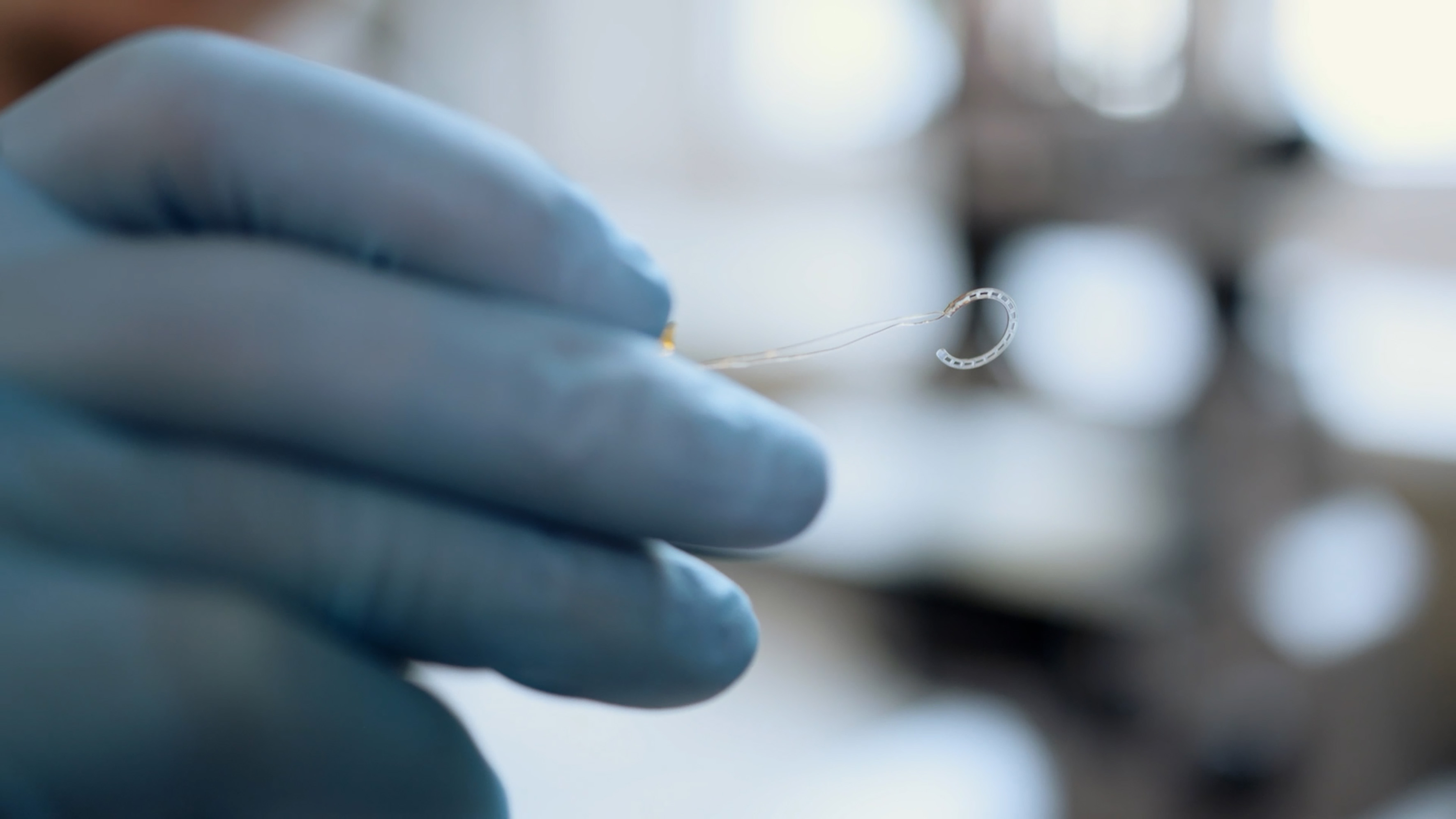 ​​One hand holds the ring-shaped, bipolar electrode at close range. The electrode was handcrafted and plated with gold.​ 