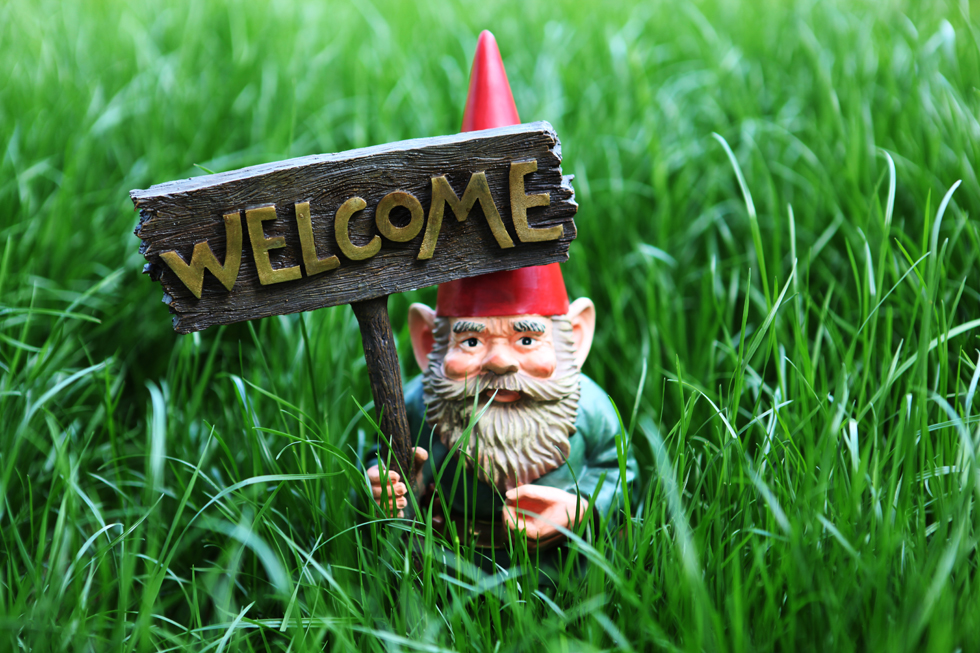 A garden gnome with a welcome sign