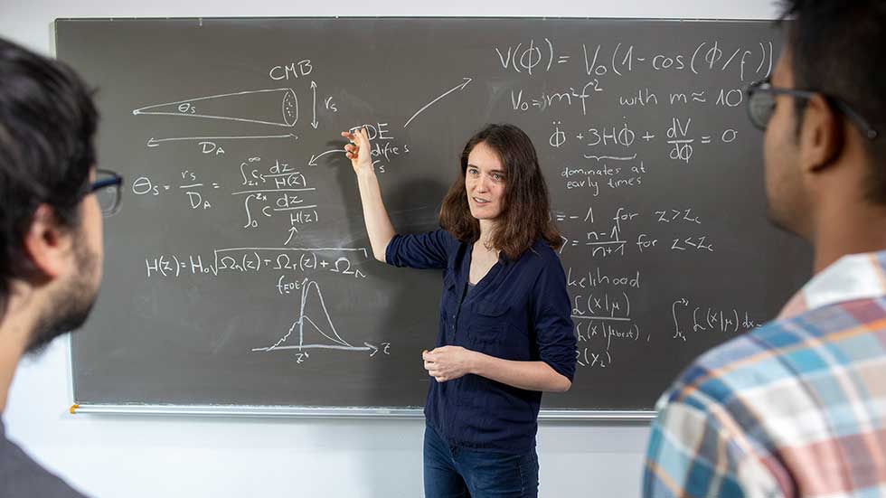A researcher is presenting the results of her work on a blackboard. 