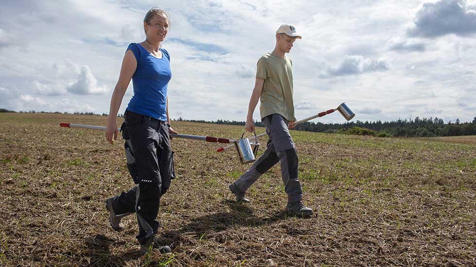 Two researchers are walking across a field.