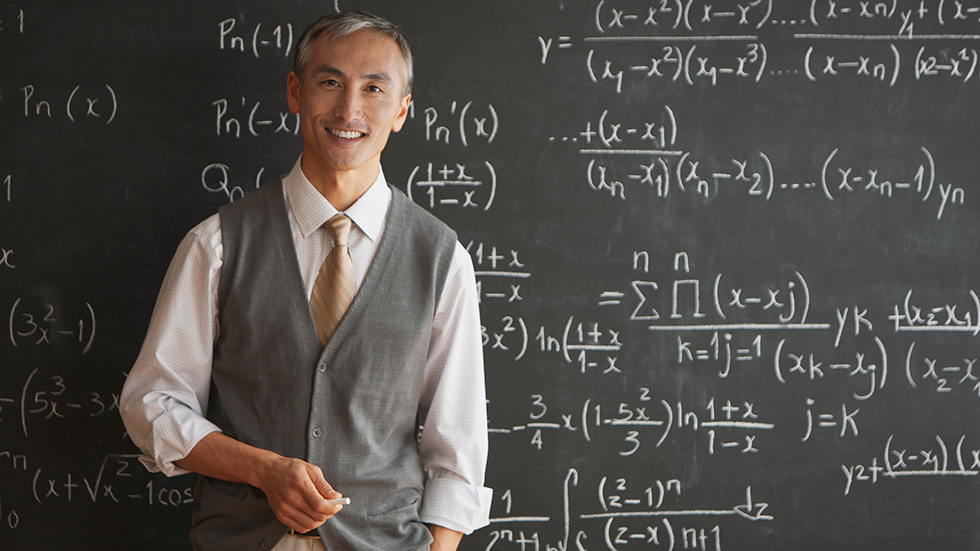 A professor standing in front of a blackboard