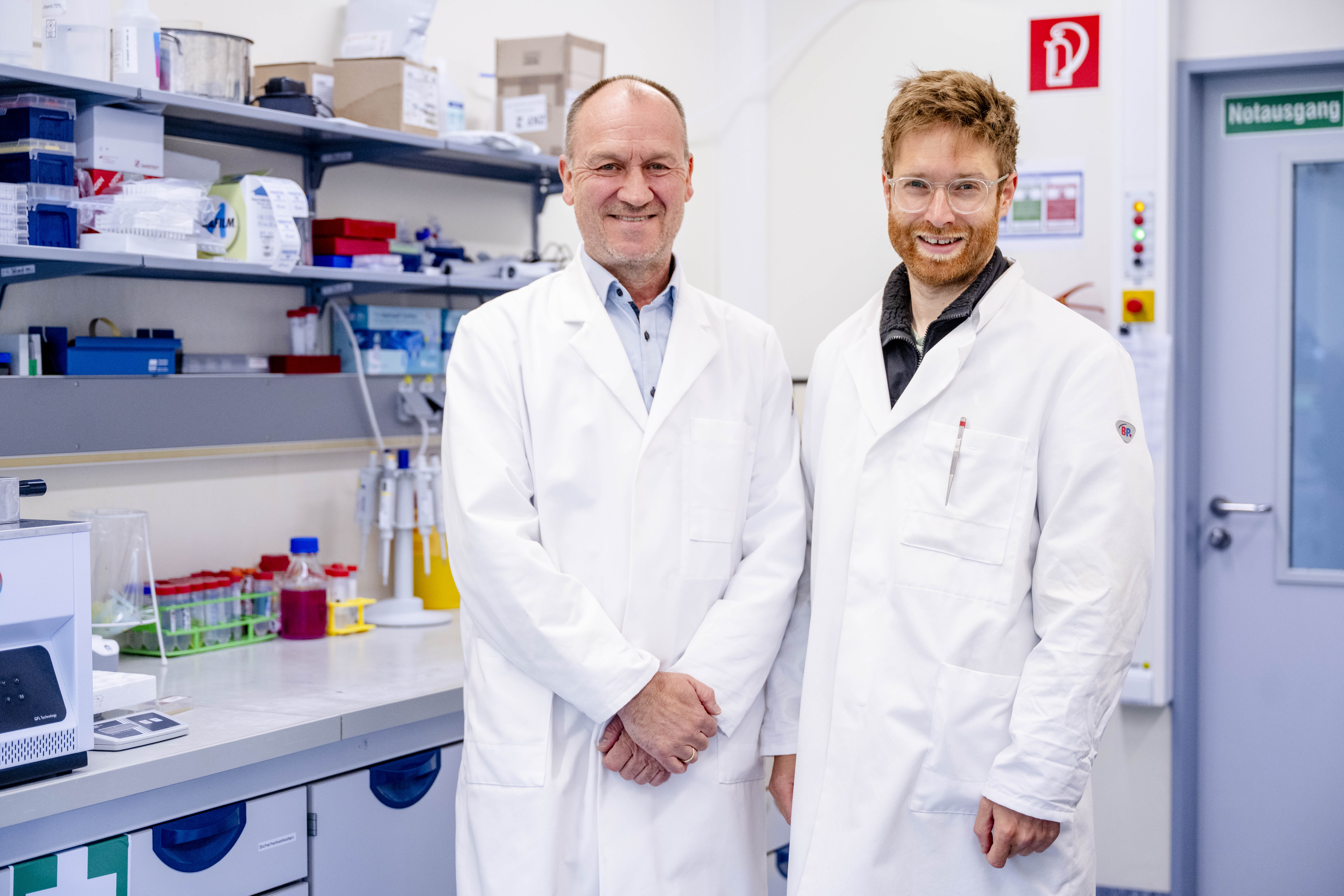 ​​​Two men in white lab coats in a laboratory​​ 